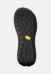 Zwarte schoenzool met ronde profielpatronen en horizontale groeven, met een geel Vibram-logo en maatnummer 38 zichtbaar.
