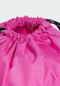 Pink fabric drawstring bag with gathered top, featuring a textured triangular pattern and black handles. Smooth, lightweight material.