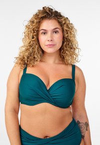 Türkisfarbener Bikini-Oberteil mit gedrehtem Vorderteil, verstellbaren Trägern und weichem, strukturiertem Stoff. Verfügt über eine klassische, gut sitzende Silhouette.