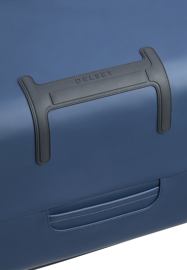 Blauer Hartschalenkoffer mit einer glatten Oberfläche, ausgestattet mit einem grauen Ledergriff und feinen Nähten. Der Markenname "DELESEY" ist in den Griff eingeprägt.