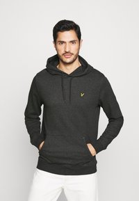 Sweatshirt à capuche gris foncé en tissu doux, avec une poche kangourou à l'avant et un petit logo vert sur la poitrine gauche.