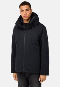 Melnā ūdensizturīgā jaka ar augstu apkakli, regulējamu kapuci, priekšējo rāvējslēdzēju un sānu kabatām ar gludu tekstūru.