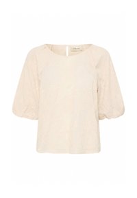 Blouse crème avec un motif floral texturé, encolure ronde et manches courtes bouffantes. Présente un détail en keyhole à l'arrière.