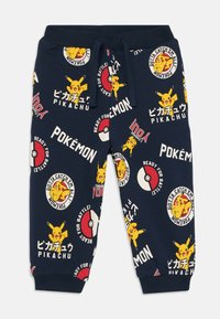 Námořnické tepláky s elastickým pasem, na kterých se opakuje potisk Pikachu a Pokéball, doplněné japonským textem.