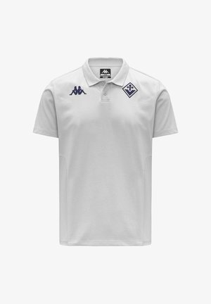 Polo blanc avec col à deux boutons, logo Kappa bleu marine sur le côté droit de la poitrine, et emblème en forme de losange bleu marine sur le côté gauche de la poitrine.