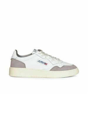 Sneaker bianca low-top con dettagli in suede grigio, suola crema, lacci e toppa con logo sul lato caratterizzata da una piccola bandiera.