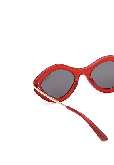 Červené sluneční brýle s oversized, zaoblenými obroučkami. Tmavé skleněné čočky s hladkým povrchem a metalickými zlatými akcenty na spáncích.