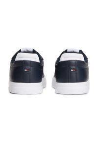 Navy leather sneakers with white rubber soles, featuring a padded collar, contrasting accents, and a small logo detail on the heel.