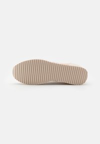 Light beige sneaker sole with a ribbed texture. Features rounded edges and a flat bottom for traction. Simple, minimalistic design.