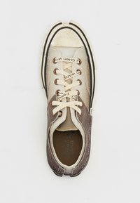 Zapatilla alta con tejido texturizado beige, acentos de cuero marrón, cordones crema y suela de goma negra con detalles de marca.