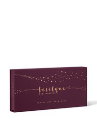Scatola rettangolare viola scuro con motivi di stelle dorate e testo dorato con scritto "le silque pure moments luxury silk sleep mask."