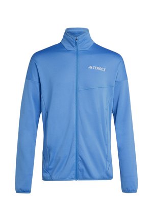 Lichtblauwe jas met volledige ritssluiting, hoge kraag en wit "TERREX"-logo op de linkerborst, lange mouwen en zijzakken.