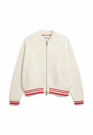 Veste bomber couleur crème avec poignets et ourlet côtelés à rayures rouges, fermeture éclair frontale, deux poches latérales et tissu texturé avec un détail de logo.