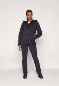 Zwarte waterdichte jas met een rits aan de voorkant en een capuchon, gecombineerd met bijpassende zwarte broek. Beide hebben een gladde textuur en een minimalistisch ontwerp.