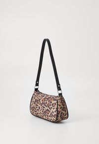 Sac à main en imprimé léopard avec un corps en tissu doux, une bandoulière noire, des détails en métal argenté et une silhouette arrondie. Fermeture zippée en haut.