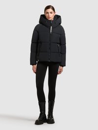 Svart puffjacka med huva, med en framdragkedja, två sidofickor och texturerad tyg. Sammanställd med svarta leggings och kängor.