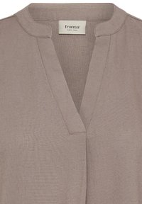 Vêtement taupe à col en V avec un petit col montant et une étiquette de la marque Fransa cousue à l'intérieur de l'encolure.