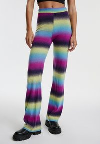 Gestreepte flarebroeken in levendige kleuren: roze, paars, blauw, groen en zwart. Zacht, rekbaar breiwerk met een hoge tailleband.