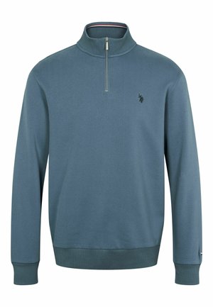 Fleecová mikina v teal farbe s vysokým golierom a polovičným zipsom. Obsahuje ribbované manžety a lem, s malým čiernym logom na hrudi.