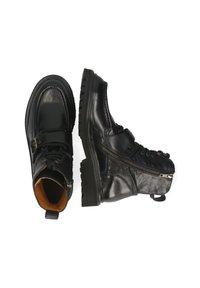 Botas tobilleras de cuero negro con suela robusta, parte delantera con cordones, cremallera lateral y un interior marrón en contraste. Presentan un acento de hebilla.