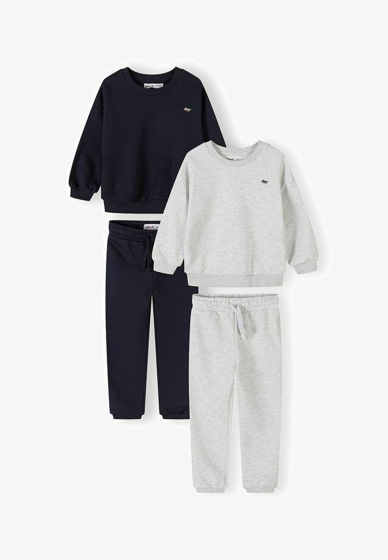 Deux ensembles de sweat-shirts et pantalons de jogging pour enfants, l'un bleu marine et l'autre gris clair, chacun avec un petit logo animal sur la poitrine.