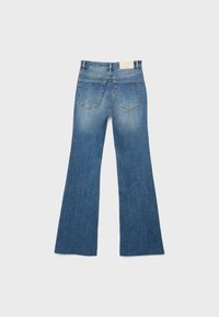 Blå denim jeans med vidde, vist bagfra med to lommer, bæltestropper, falmede områder og en hvid mærkebetiket på linningen.