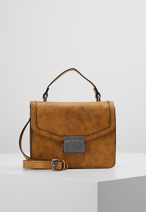 Bolso de mano de cuero marrón con asa superior, solapa frontal, cierre rectangular plateado y correa de hombro desmontable, exhibido sobre plataforma blanca.