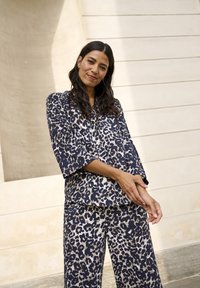 Navy Leopardenmuster-Loungewear-Set mit weitem Ärmel und lässig geschnittenen Hosen. Weicher Stoff mit glatter Textur und dezenter Ausstrahlung.