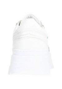 Scarpe da ginnastica bianche con una superficie liscia simile alla pelle, suola in gomma spessa e dettagli di cucitura sul retro. Design minimalista.