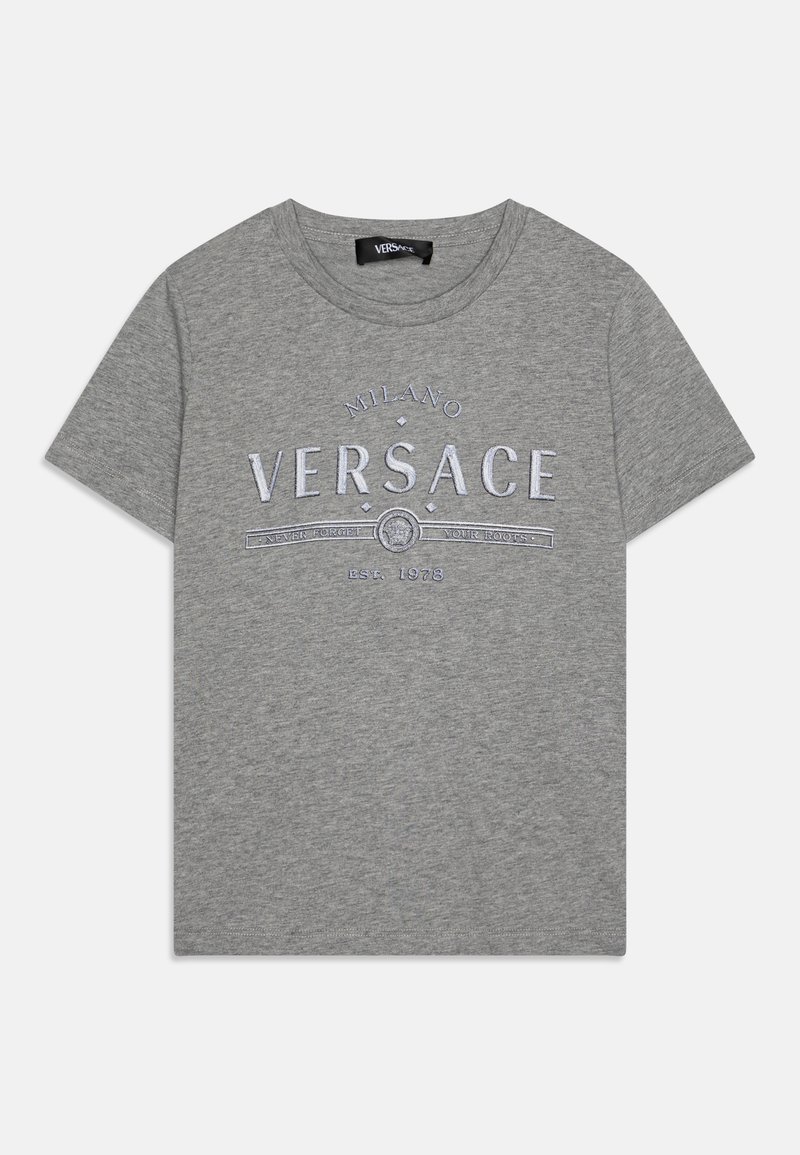 Siva bombažna majica s kratkimi rokavi, ki ima izvezene besede "Milano Versace" v beli barvi s dekorativnimi elementi in podrobnostjo "EST. 1978" blizu roba.