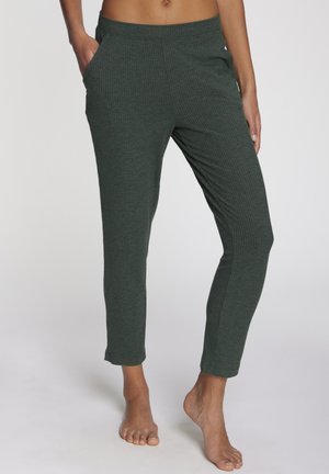 Green ribbed lounge pants with an elastic waistband and side pockets, featuring a tapered cut and soft texture.