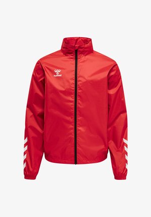 Rød sportstrøje med lynlås og høj krave, hvid Hummel-logo på brystet og hvide skrå striber på begge ærmer.