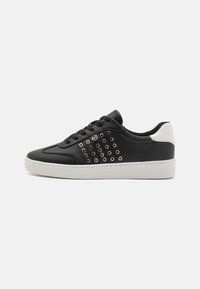 Sneaker in pelle nera con tallone bianco, caratterizzate da un motivo di occhielli metallici sul lato e una suola in gomma bianca, logo in rilievo sul tallone.