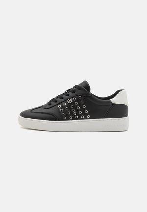 Black leather sneakers with white heel, featuring metal eyelets pattern on the side and a white rubber sole, embossed logo on heel.