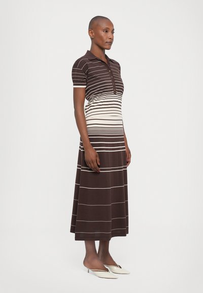 Gestreiftes Polokleid in Braun und Beige. Kurze Ärmel, Knopfleiste, Oberschenkel-lange Länge, weicher Stoff mit glatter Textur. Weiße Akzentstreifen.