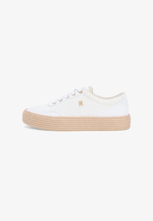 Białe trampki niskie z beżową, fakturowaną podeszwą, białymi sznurowadłami, złotymi oczkami i małym złotym logo z boku, pokazane z profilu.