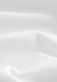 Tissu blanc à la texture lisse, présentant de légères rides et plis. La surface possède un fin motif de tissage, ce qui contribue à son apparence légère.