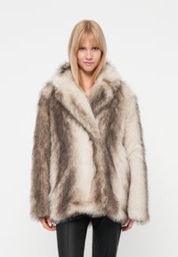 Abrigo de piel sintética que presenta una mezcla de tonos beige y marrón, con mangas largas y un collar amplio. Textura suave con una silueta holgada.