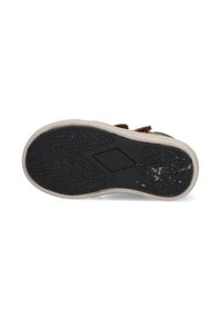 Bruine suède schoen met een gestructureerde zwarte rubberen zool, met een ruitpatroon en een beige accent rond de rand van de zool.