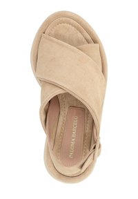 Sandale en suède beige avec un design à brides croisées, bout arrondi, texture douce et semelle intérieure rembourrée. Le nom de la marque est embossé à l'intérieur.