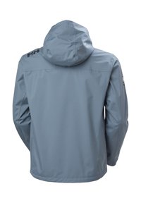 Giacca impermeabile azzurro chiaro con cappuccio, maniche lunghe e un piccolo logo sulla parte superiore della spalla sinistra e sulla manica destra, vista da dietro.