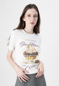 White short-sleeve t-shirt featuring a colorful ice cream graphic with text "Glace Maison" and cherries. Smooth cotton fabric with a casual fit.