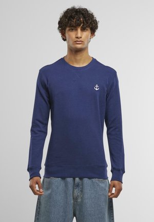 Felpa blu navy con maniche lunghe, collo rotondo e logo ancorato bianco sul petto. Realizzata in un tessuto morbido con polsini e orlo a coste.