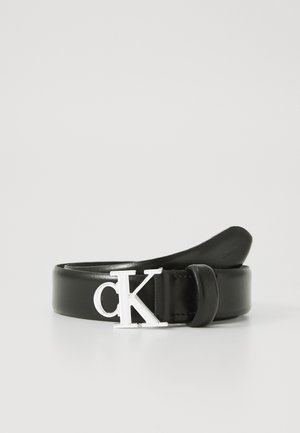 Schwarzer Ledergürtel mit silberner verschlungener "cK"-Logoschnalle, auf einer weißen Oberfläche aufgewickelt.