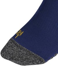 Námořnické ponožky s vyztuženou tmavě šedou špičkou a patou, s texturovaným pleteným vzorem a malým žlutým logem poblíž manžety.