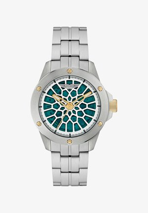 Montre en acier inoxydable avec un cadran à motifs teal, des accents dorés et trois aiguilles. Les caractéristiques incluent une couronne et un bracelet à maillons.