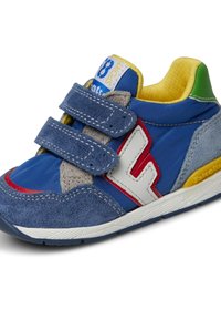 Blå träningssko med mocka och syntetiska material. Har två justerbara kardborreband, röda och vita detaljer, strukturerad sula och gul innersula.