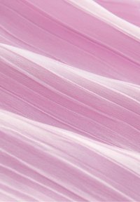 Tissu rose clair avec une texture douce et légère, présentant de subtils plis et une surface lisse, créant un motif de vagues doux.