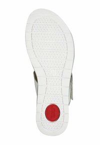 Semelle de chaussure en caoutchouc blanc avec une surface antidérapante texturée, des motifs circulaires et un accent circulaire rouge portant l'inscription « Confort ». Présente des bords rainurés.