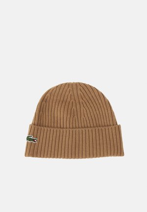 Bonnet en tricot marron avec une texture côtelée et un revers plié. Présente un petit logo de crocodile vert sur le côté.